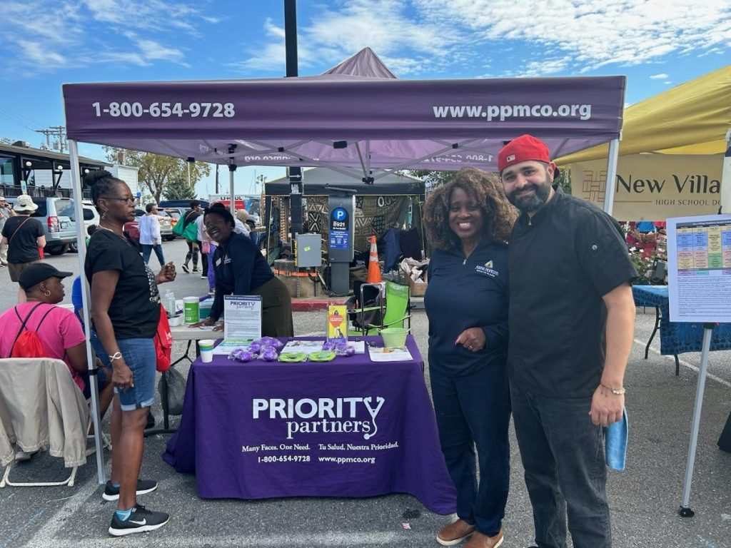 Dr. Everett poses with Chef Giacomo outside our Priority_Partners tent and Table at the Kunta Kinte Festival